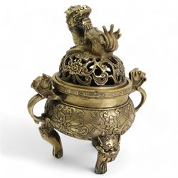 Chinese polished bronze incense burner and cover, pierced domed cover with temple lion finial, the base cast with scrolling foliage on tripod temple lion mask legs, Xuande seal mark, H18cm 