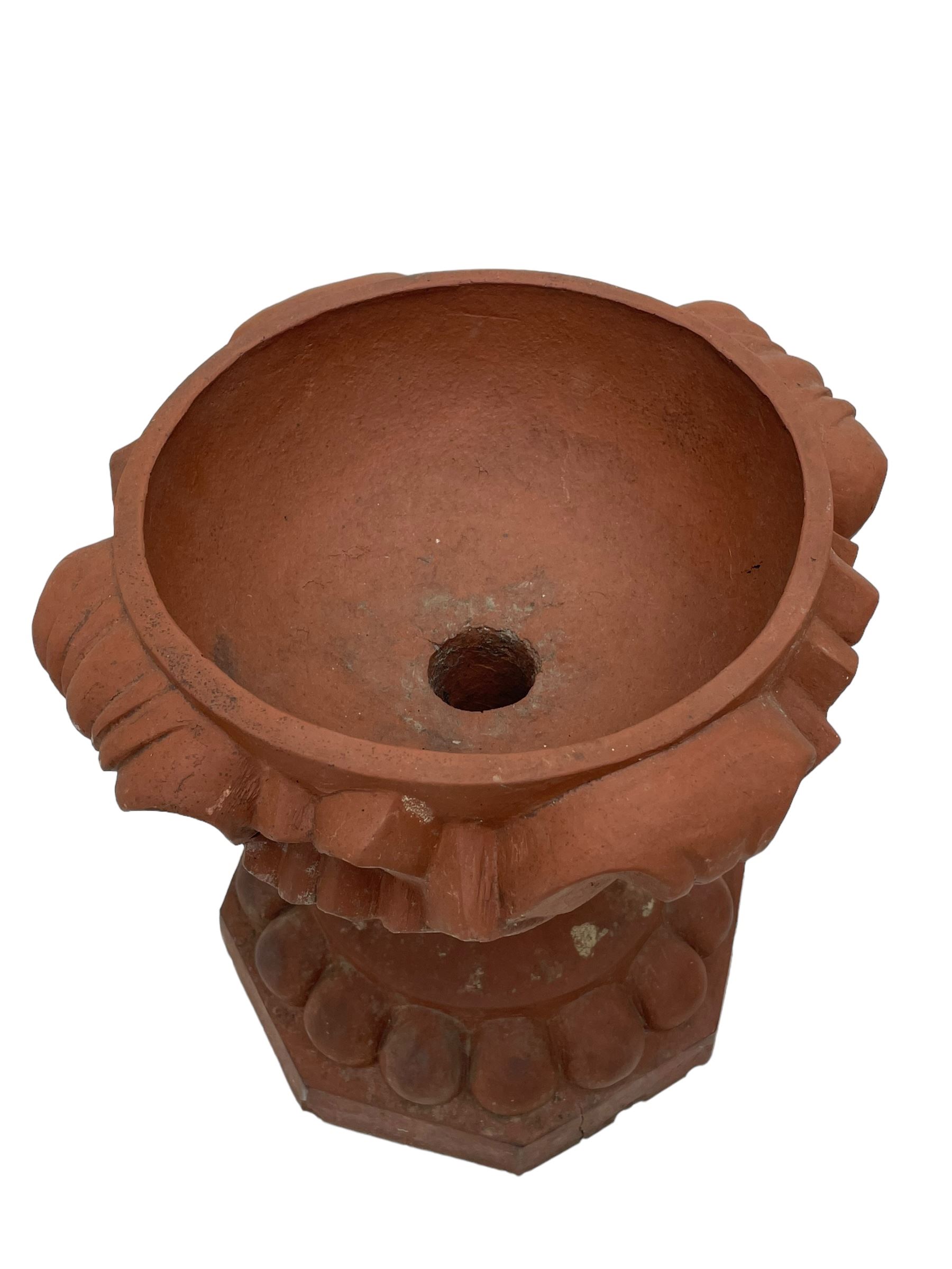 Pair of late 19th to early 20th century red terracotta garden urn planters, the shallow bowls moulded with curled acanthus leaf decoration, on circular foot with globular beaded moulding, octagonal base