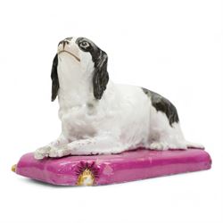 Mid 19th century Copeland & Garrett model of a recumbent spaniel upon a pink tasselled cushion, printed marks beneath, L20cm x H12cm