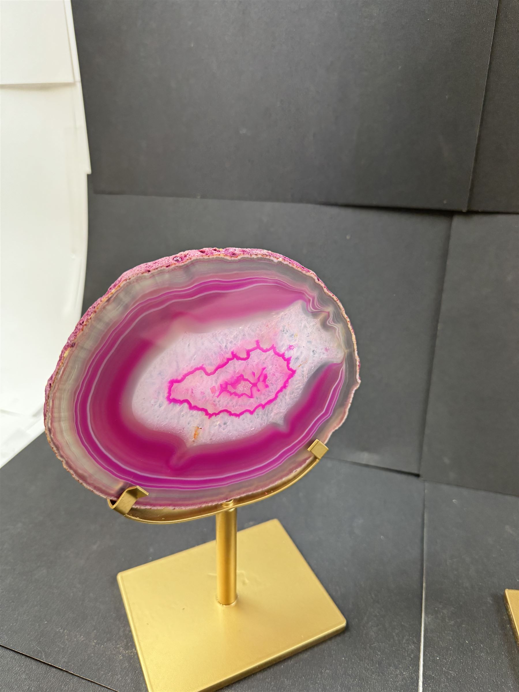 Pair of pink agate slices, polished with rough edges, raised upon gilt metal stands, H20cm