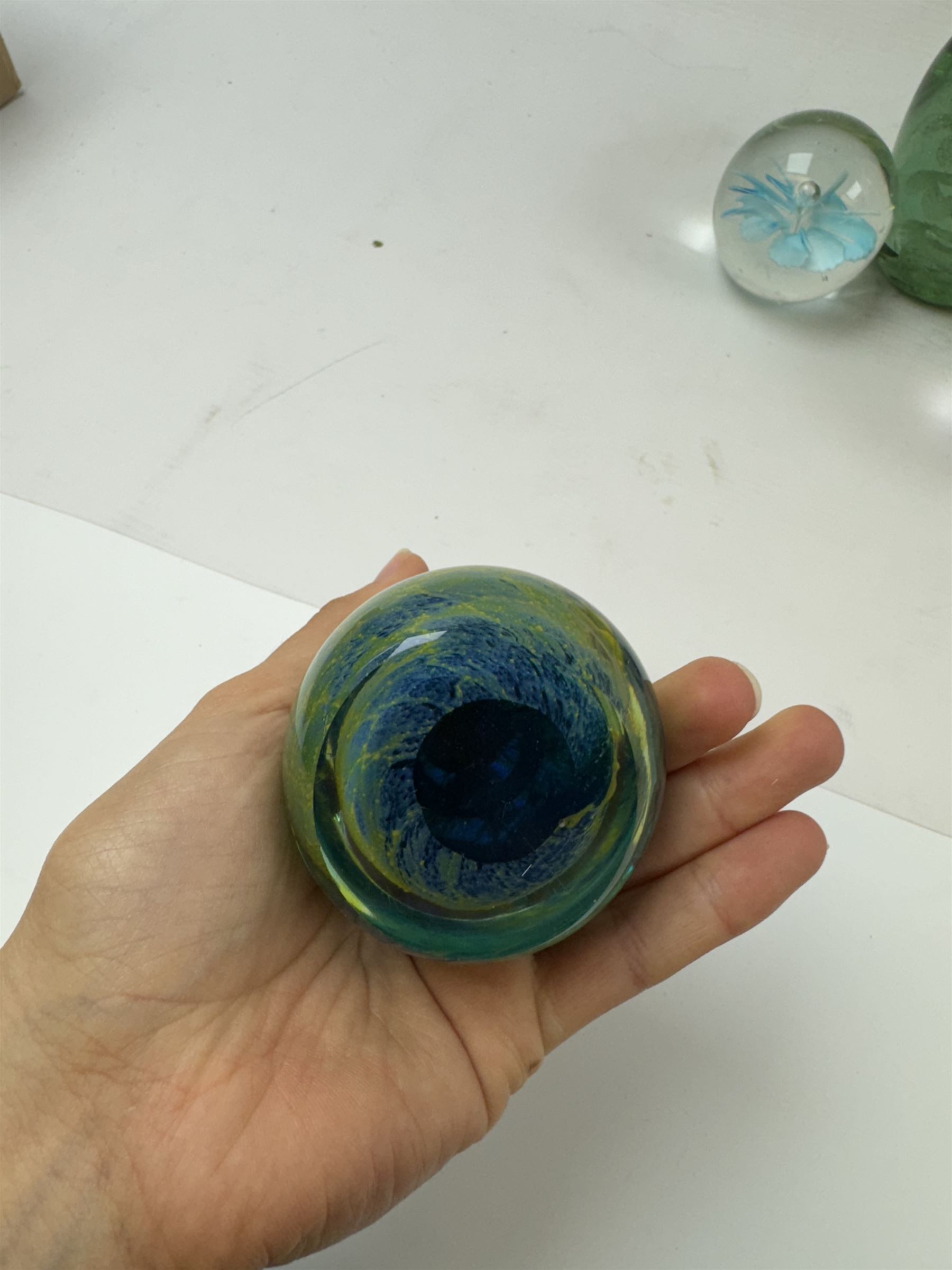 Two glass dump paperweights, with flower inclusions, together with four further glass paperweights