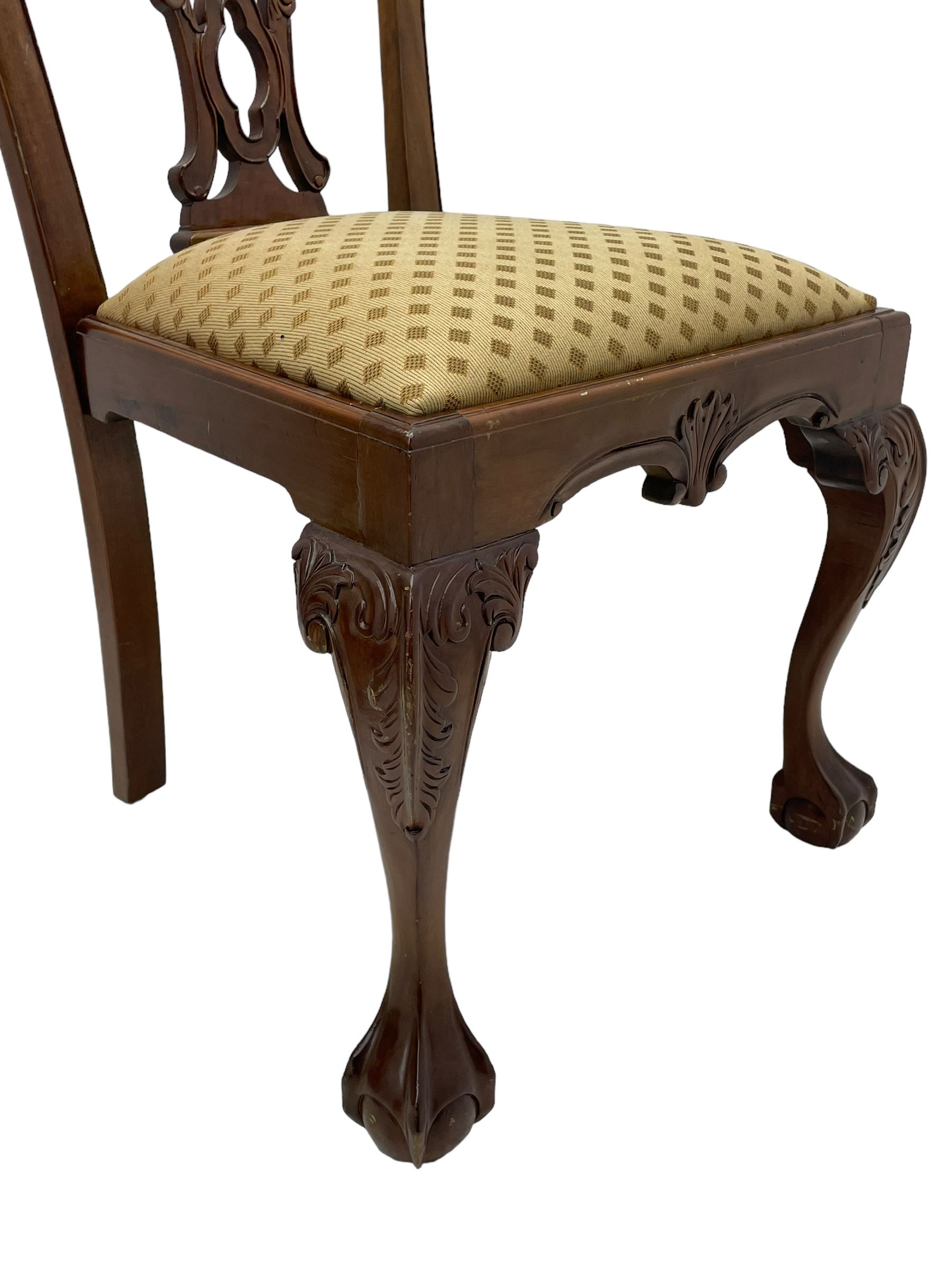 Set of twelve Chippendale design mahogany dining chairs, shaped cresting rail carved with foliage and C-scrolls, pierced interlaced splat with curled leaf decoration, upholstered drop-in seat, moulded seat rails, on scrolled acanthus carved cabriole supports with ball and claw feet 