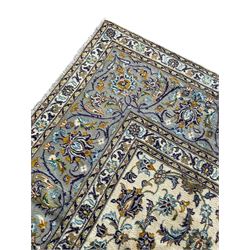 Persian Kashan ivory ground carpet, the busy field decorated with scrolling and interlaced leafy branches and palmettes, trailing branch border with repeating stylised plant motifs, within floral pattern guard stripes 