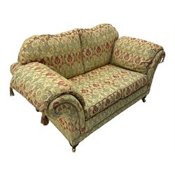 Traditional design two seat sofa, high back with scrolled arms, upholstered in beige fabric with red and green damask motifs, on castor supports (L178cm, D100cm, H89cm); matching armchair (L109cm, D89cm, H89cm)