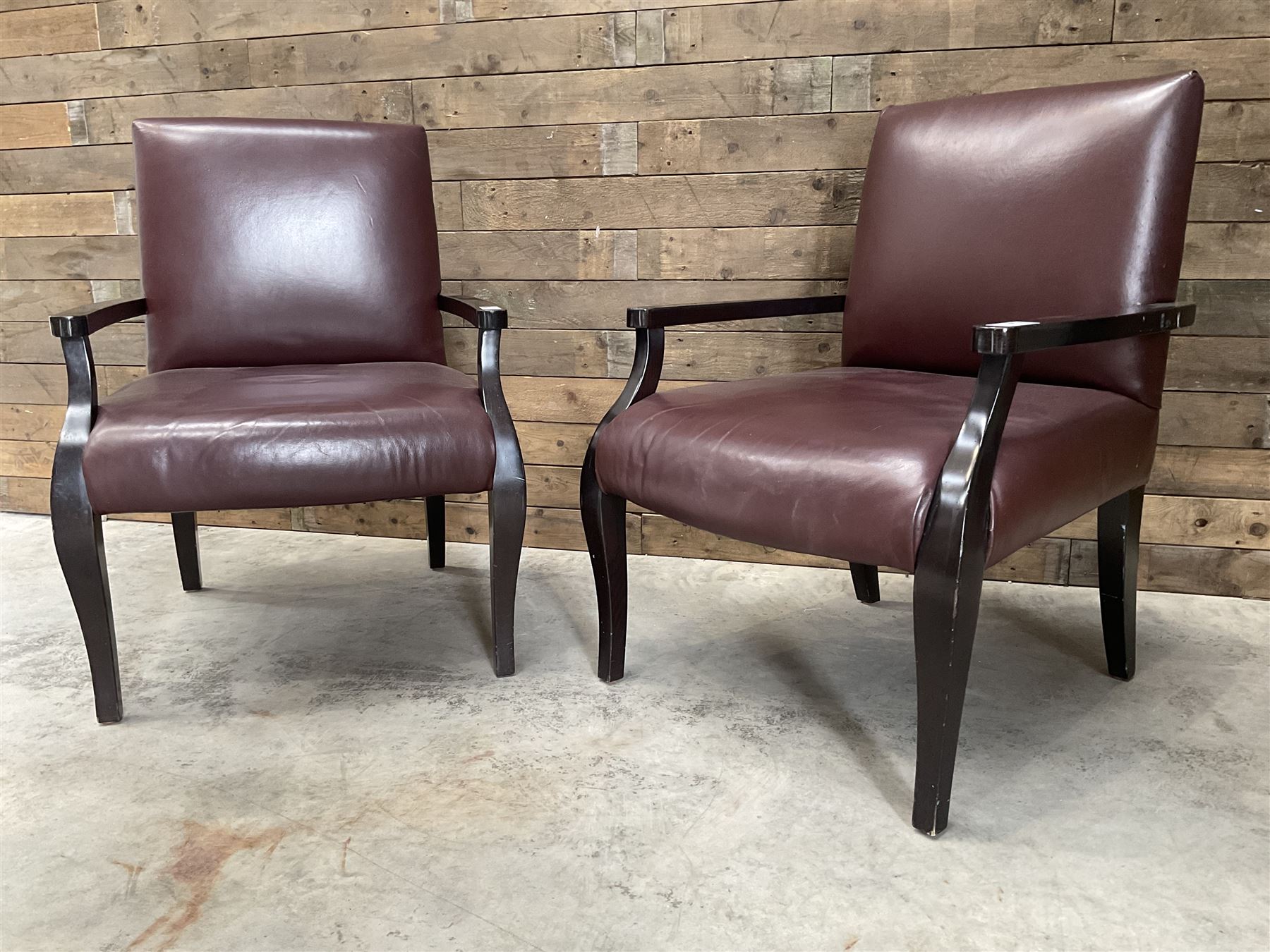 Two rosewood framed armchairs, upholstered in brown leather