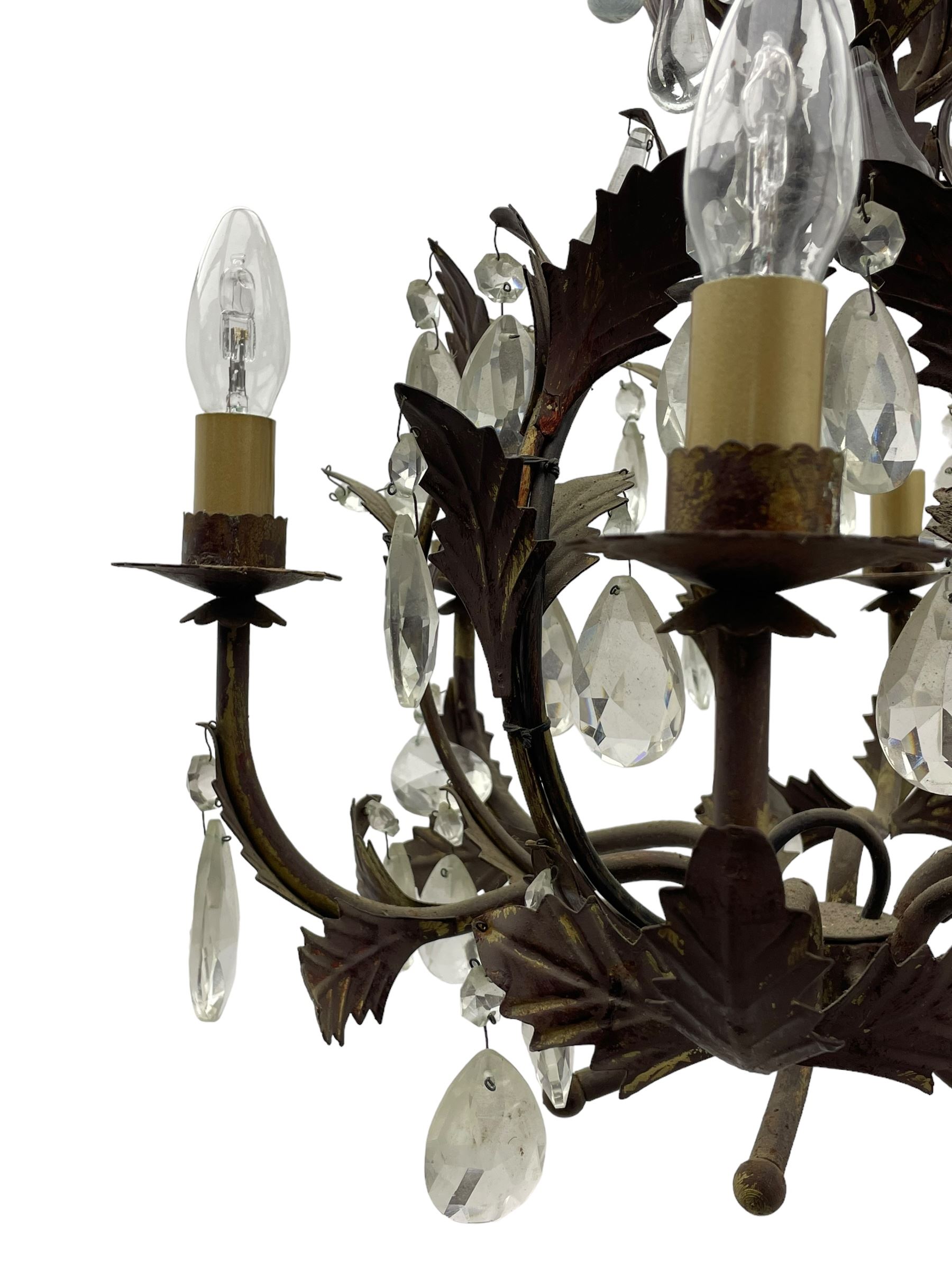 Early 20th century wrought metal chandelier, of scrolled form with six branches, decorated with leafage and glass pendants 