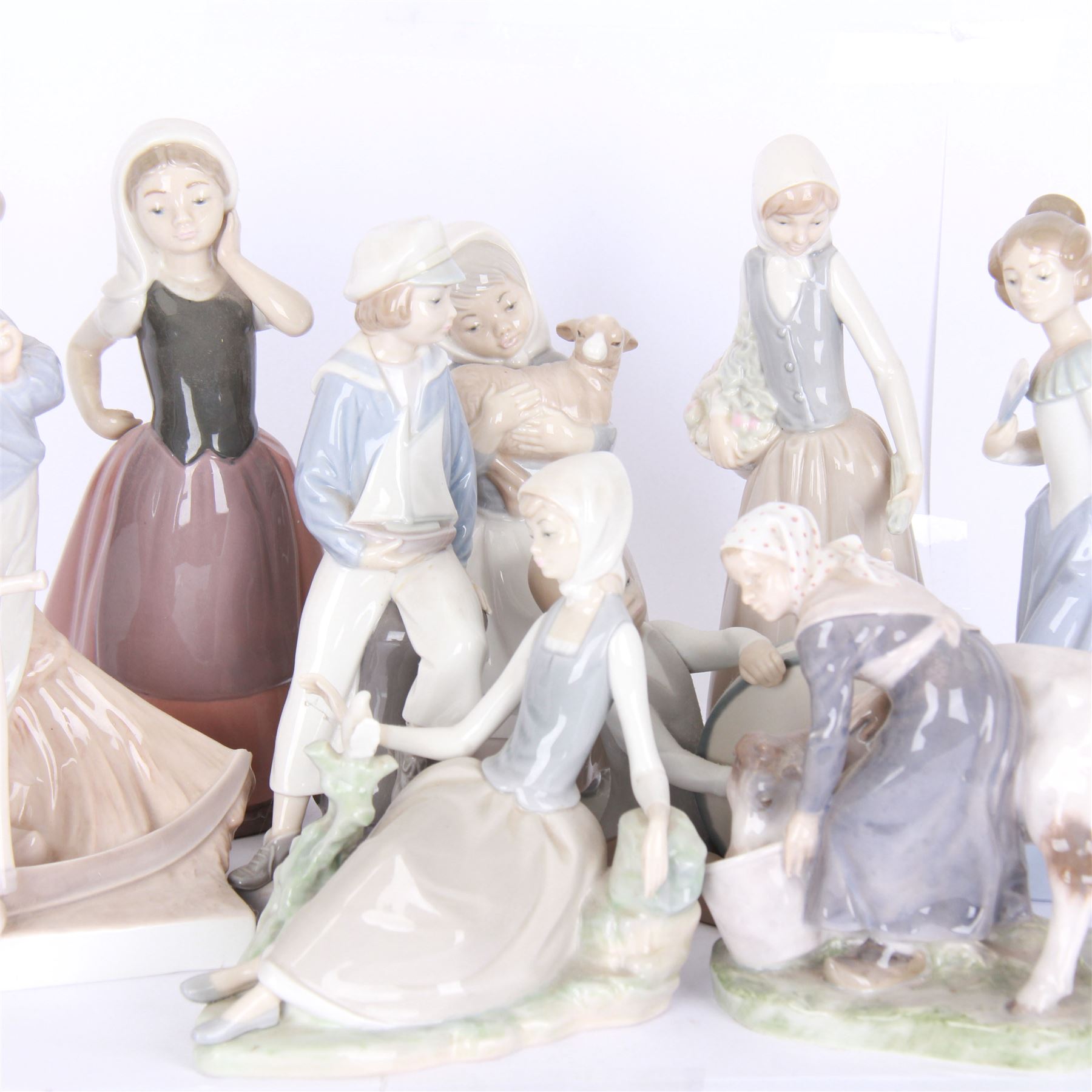 Two Royal Copenhagen figures, comprising girl with cow, 779 and Farmer with scythe, no 685 , together with two Lladro figures, and similar 