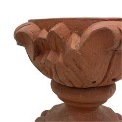 Pair of late 19th to early 20th century red terracotta garden urn planters, the shallow bowls moulded with curled acanthus leaf decoration, on circular foot with globular beaded moulding, octagonal base