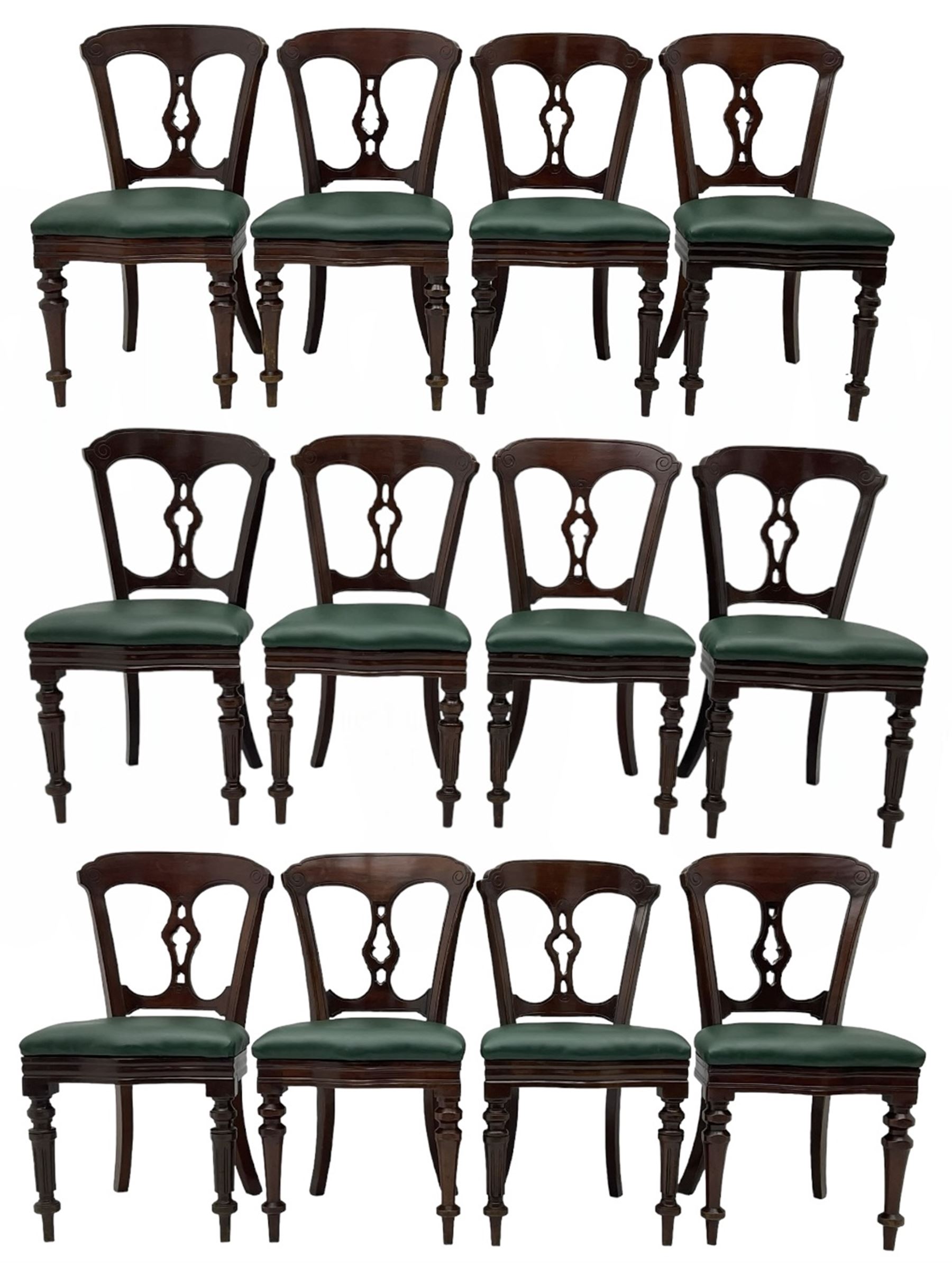 Matched set of twelve Victorian mahogany dining or boardroom chairs, the shaped cresting rail decorated with scrolled decoration, upholstered drop-on seats upholstered in green fabric, on turned supports  