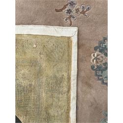 Chinese washed woollen pink ground rug, decorated with floral bouquets and Chinese symbols 