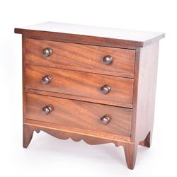 19th century mahogany miniature chest of drawers, with three graduating drawers, each with wooden handles, with inlaid shaped front and upon four bracket feet, H24cm