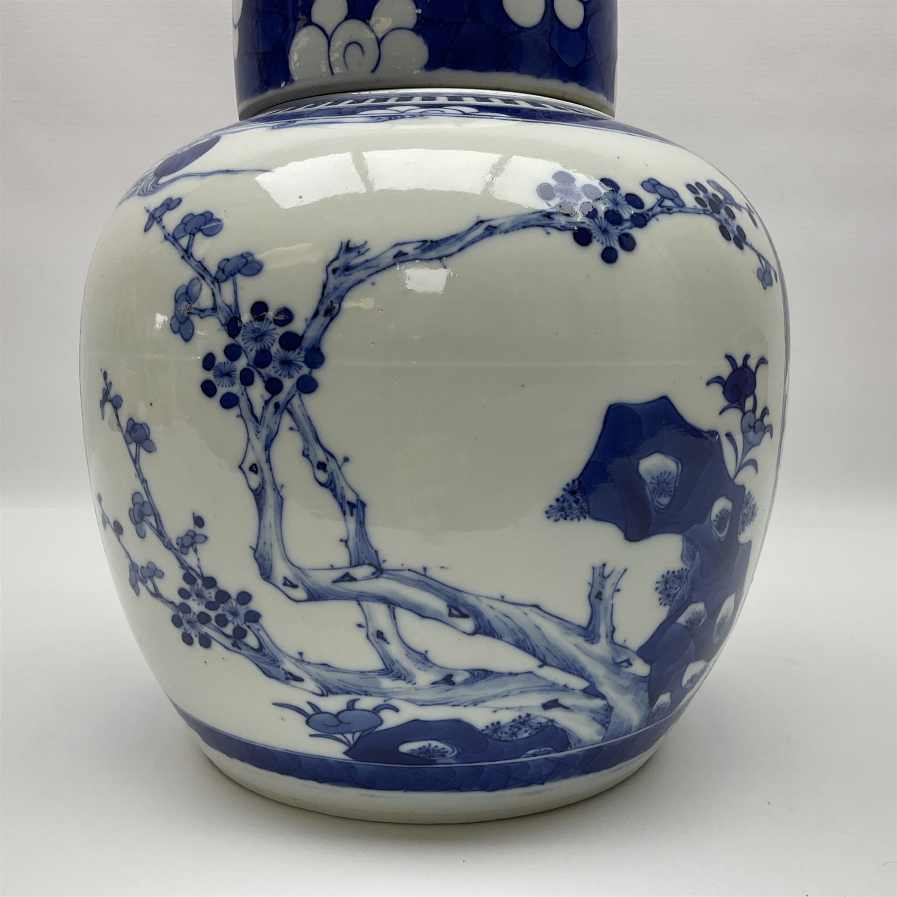 Chinese blue and white ginger jar, painted with bamboo and blossoming trees in panels against a flowerhead ground, H24cm