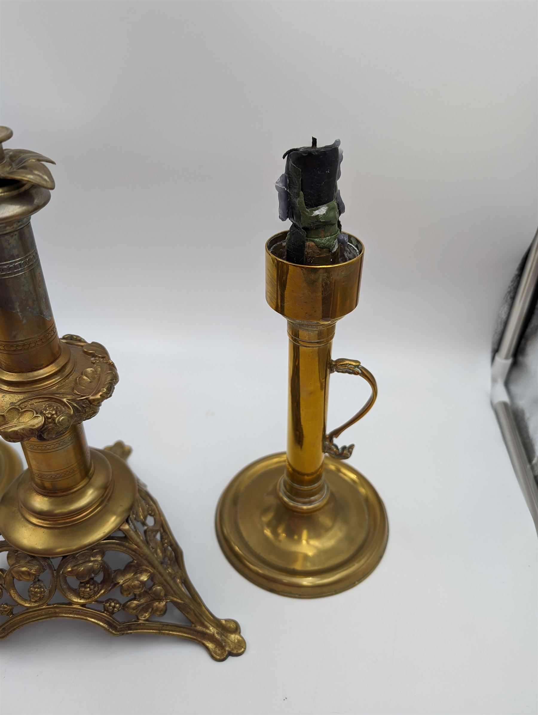 Brass candlestick with a knopt stems and triform base, together with two other brass candlestick 