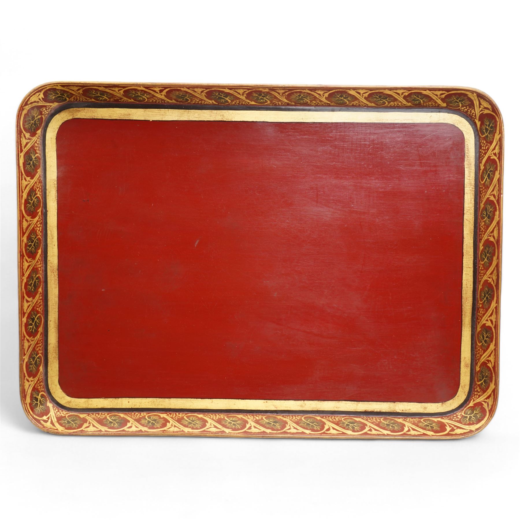 Regency red-japanned and parcel gilt papier-mâché tray, of rectangular form, decorated with a band of leaves and flowers, with trailing foliage to the exterior, L81cm x W59cm