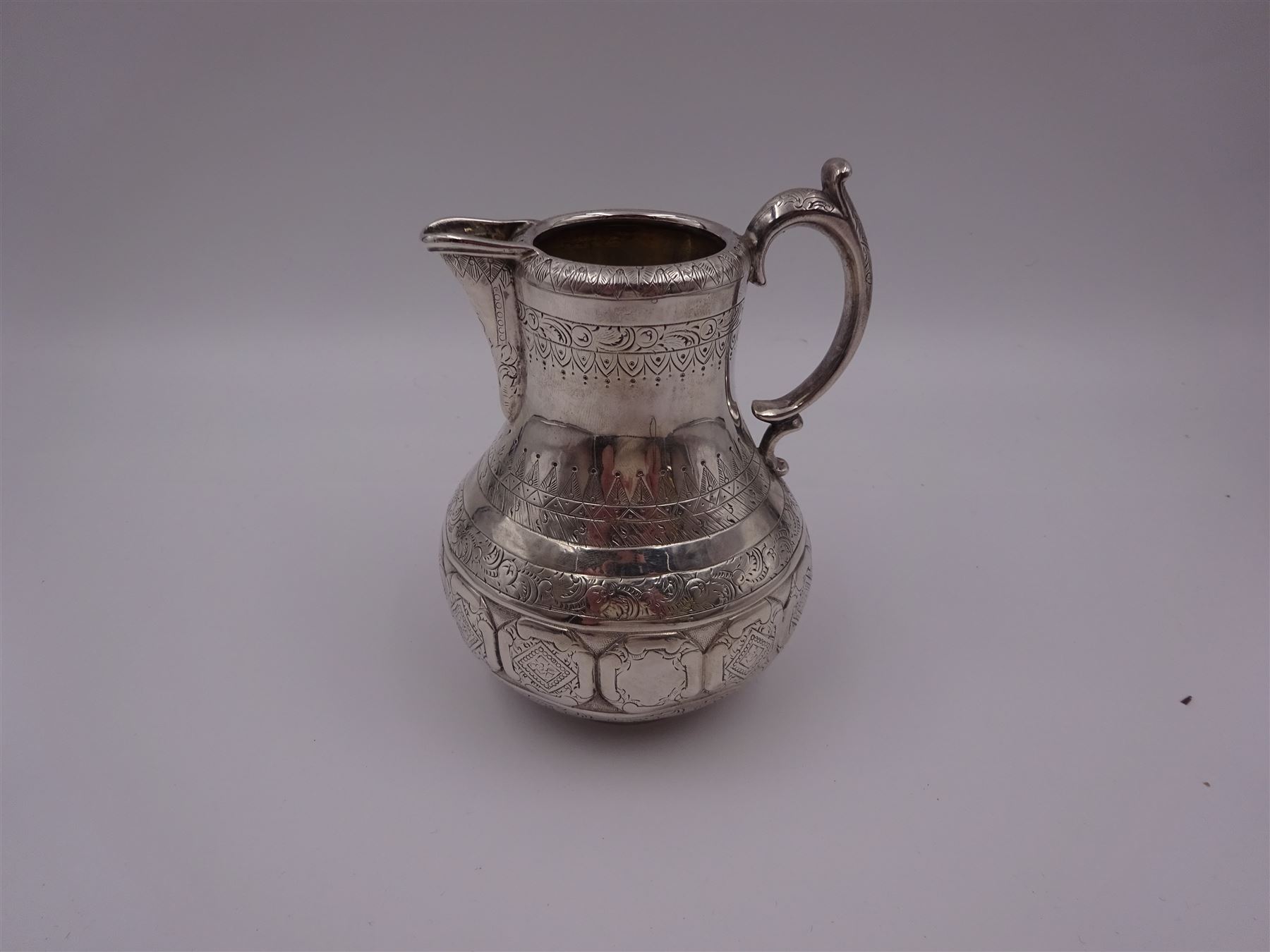 Arts and Crafts silver jug, of bellied form with C handle, the body engraved with a band of floral panels, with engraved scrolling and foliate decoration throughout, hallmarked hallmarked Samuel Smily, Goldsmiths Alliance, London 1873, H13cm