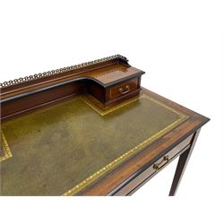 Edwardian inlaid mahogany writing desk, raised back with gilt metal gallery over two small drawers with satinwood banding, the rectangular moulded top with green leather inset writing surface, fitted with two drawers, on square tapering supports with spade feet, brass and ceramic castors 