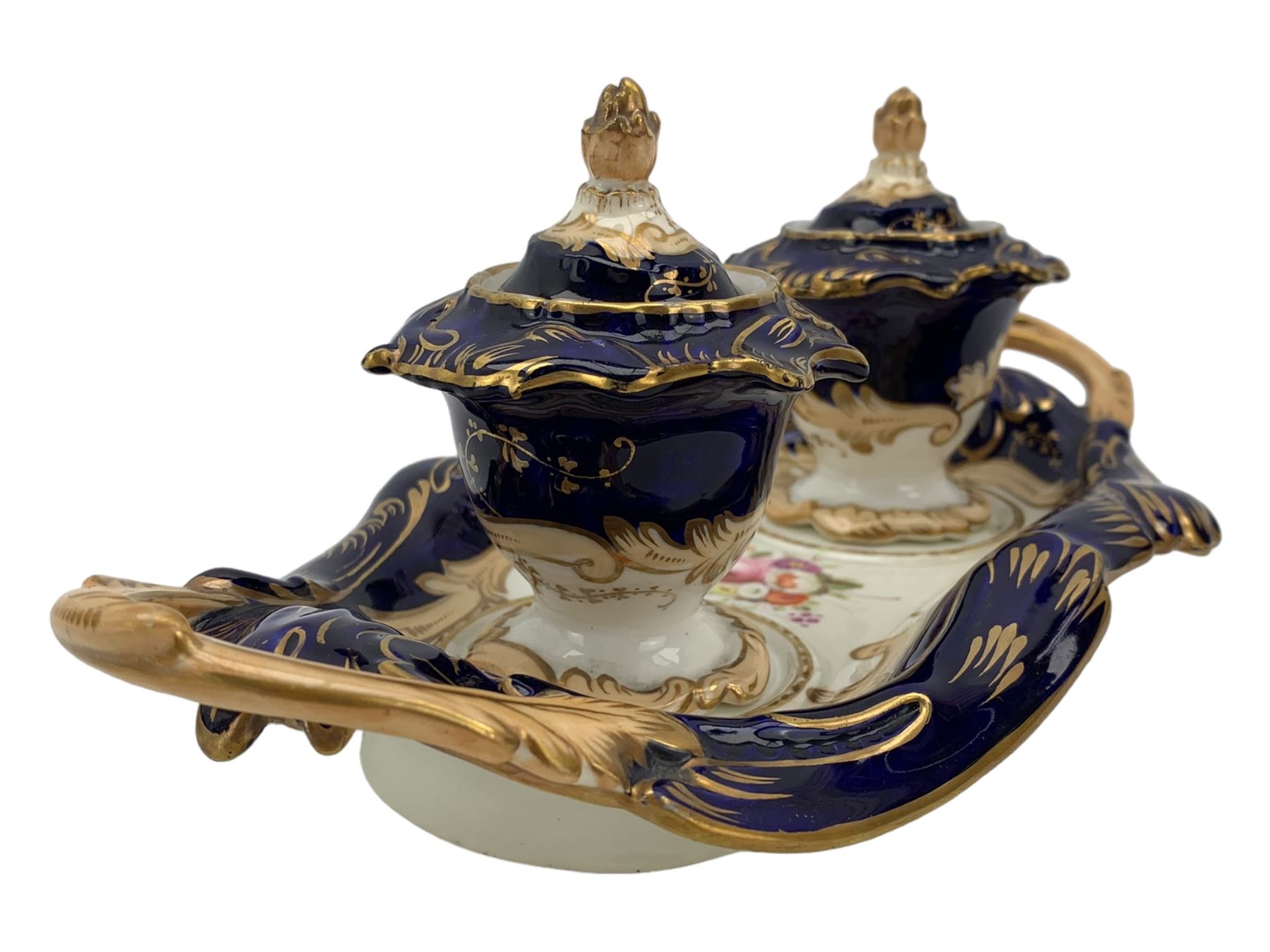 19th century porcelain inkstand, the oblong twin handled base centrally painted with a floral bouquet, flanked by two footed inkwells and covers, with rococo-inspired acanthus moulded borders and handles, pattern no. 2/3339, L26.5cm 