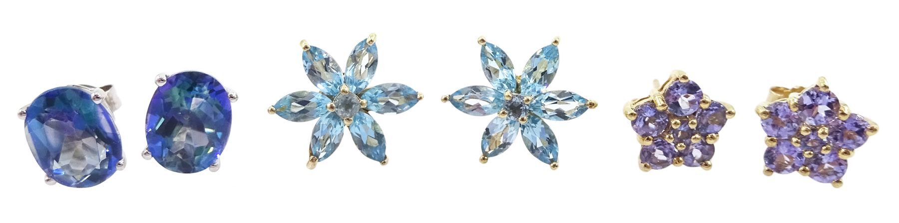 Two pairs of 9ct gold flower head stud earrings including tanzanite and topaz and a pair of 10ct white gold oval mystic blue topaz stud earrings, stamped