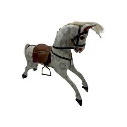 Mid 20th century rocking horse, dappled grey painted horse with applied mane and tail, red leather saddle and bridle accented with brass studs, supported by a stained wooden frame with turned supports and iron brackets, mounted on rockers