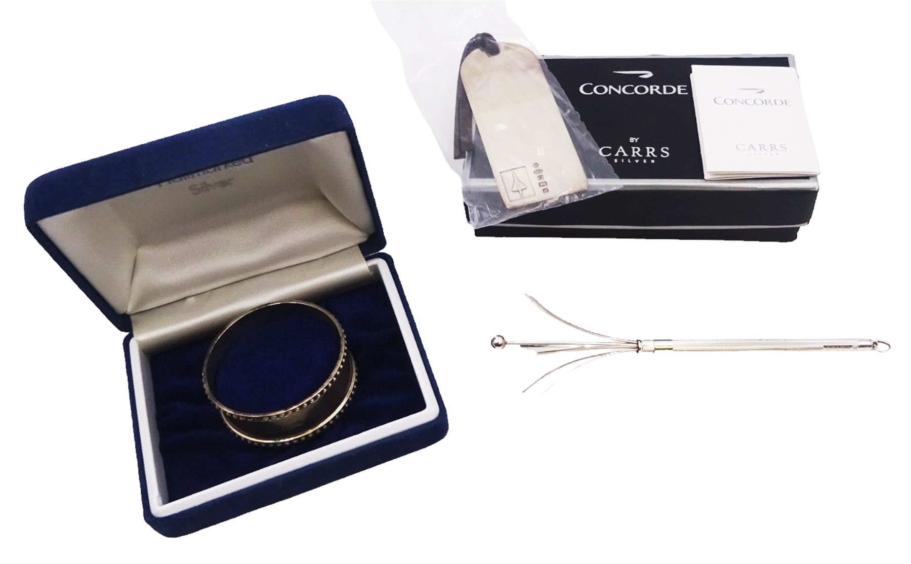 Group of modern silver, comprising swizzle stick, hallmarked Birmingham 2008, maker CJS, Concord luggage lapel, hallmarked Carrs, Sheffield 2003, and a napkin ring, hallmarked Laurence R Watson & Co, Birmingham, date letter worn, possibly 1980, lapel and napkin ring boxed 