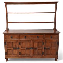 Acornman - oak dresser, raised two heights plate rack over three drawers and panelled cupboards, fitted with wrought metal fittings and handles, carved with acorn signature, by Alan Grainger, Brandsby, York 