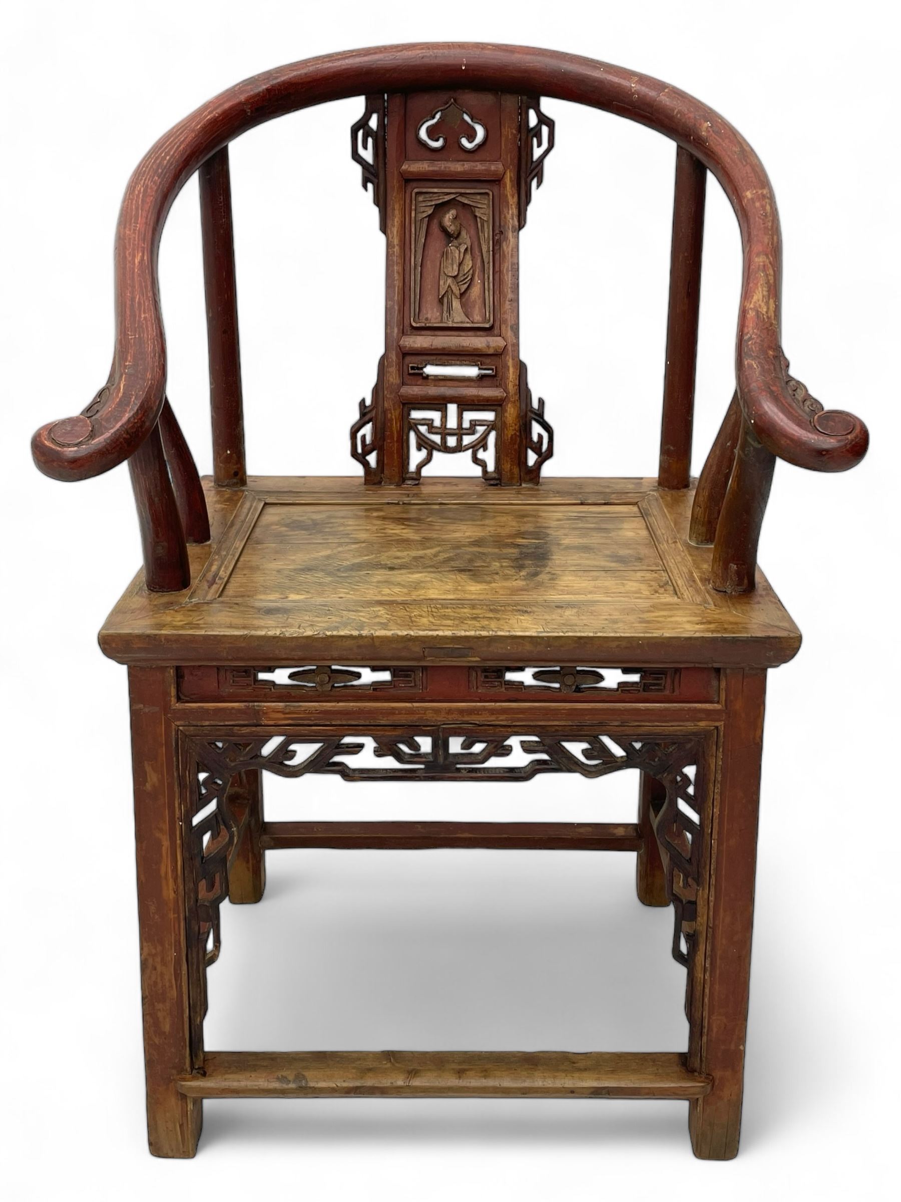 Late 19th century Chinese Qing dynasty horse shoe armchair, in elm, hung mu and Chinese softwood, horse shoe shaped upper rail carved with scroll terminals, shape back carved with solitary figure in robes, rectangular panelled seat in moulded frame, decorated with fretwork panels, on square supports united by stretchers 