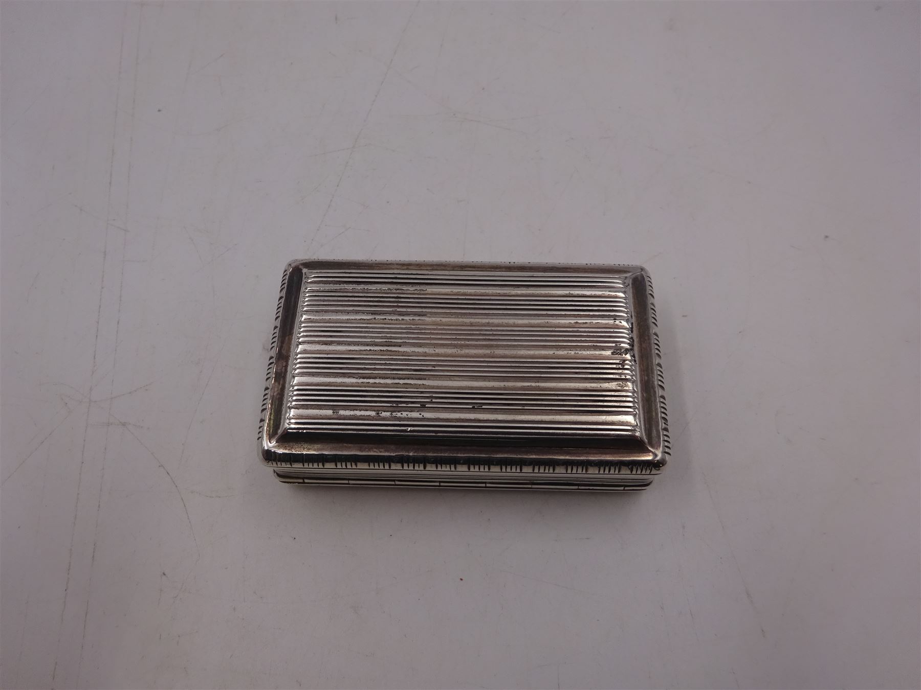 George III silver snuff box, of rectangular form, with banded decoration throughout and engraved cartouche to hinged cover, hallmarked John Shaw, Birmingham 1813, W7cm