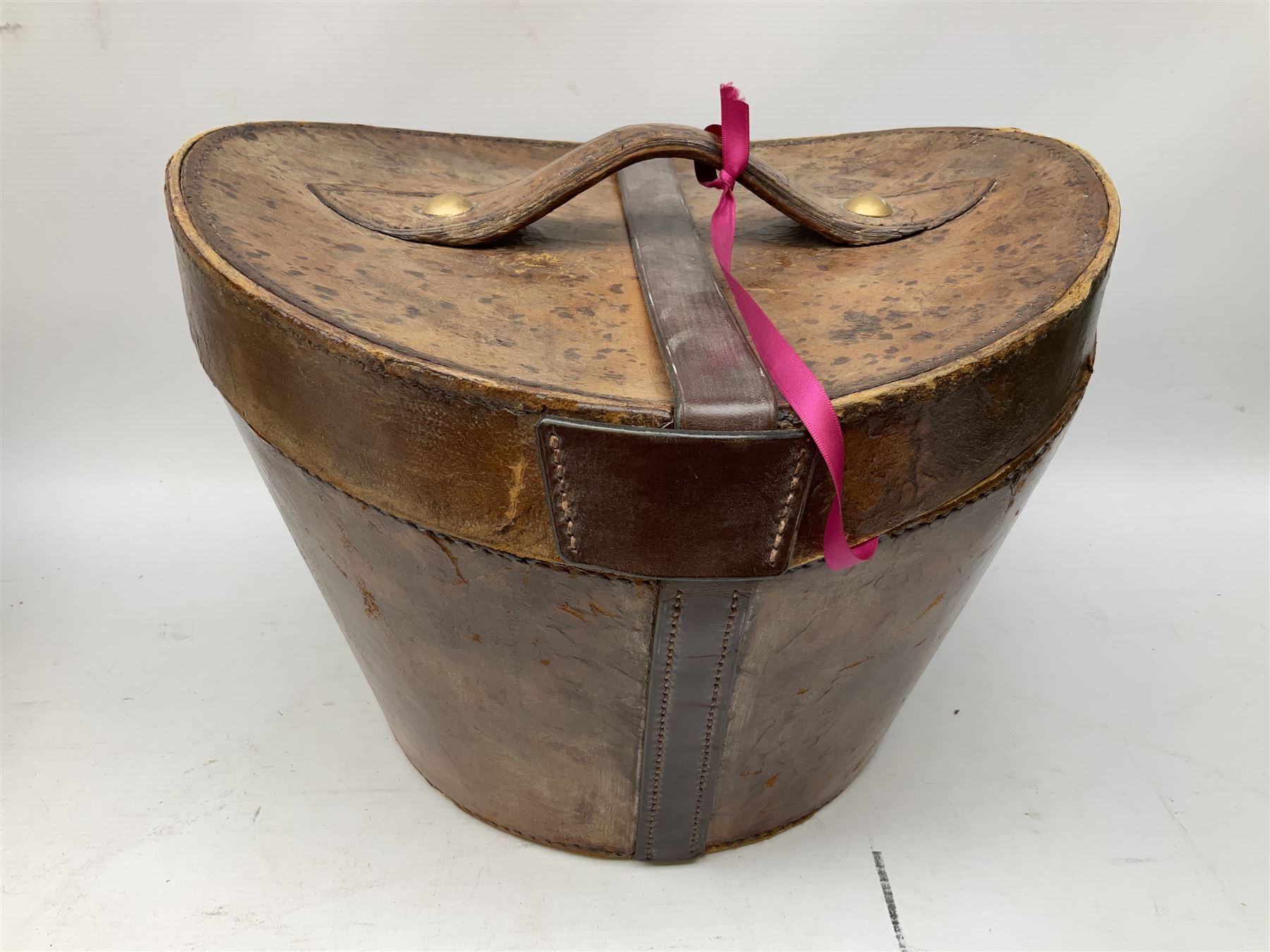 Leather hat box containing black felt top hat with 'British Manufacture' label, together with a grey top hat with 'Allens of Harrogate' label 