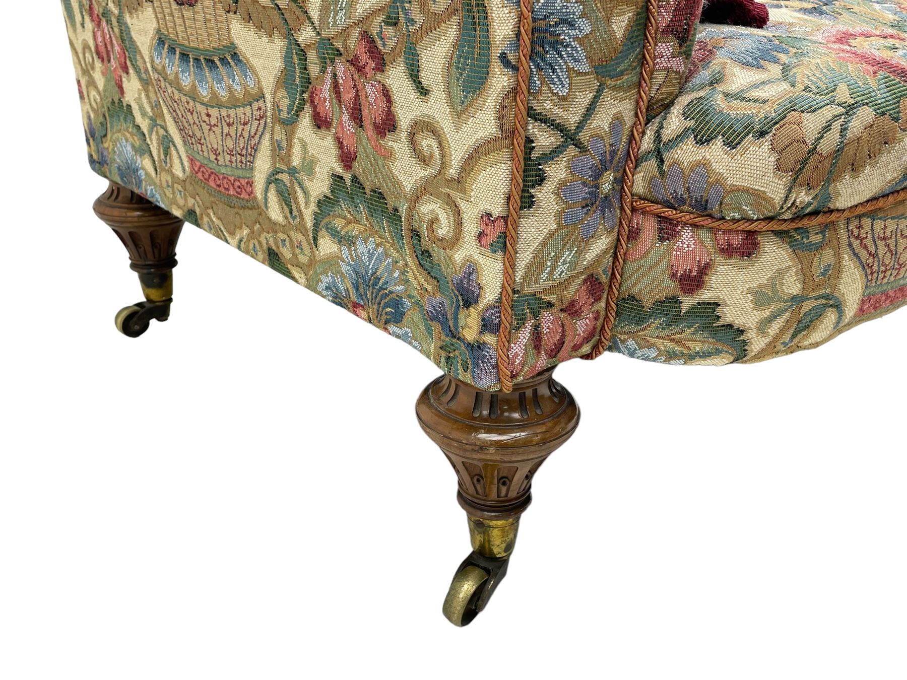 Mid-19th century walnut framed two-seat sofa, rolled arms over sprung seat, single drop-end action, raised on turned and fluted feet with brass cups and castors, upholstered by E & S Gott in traditional floral pattern fabric decorated with urns