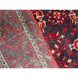 Persian Baluchi dark indigo and crimson ground rug, the field decorated with rows of repeating Pitrak motifs and surrounded by small bird and flower head motifs, floral urn decorated spandrels, repeating Pitrak border within guard stripes