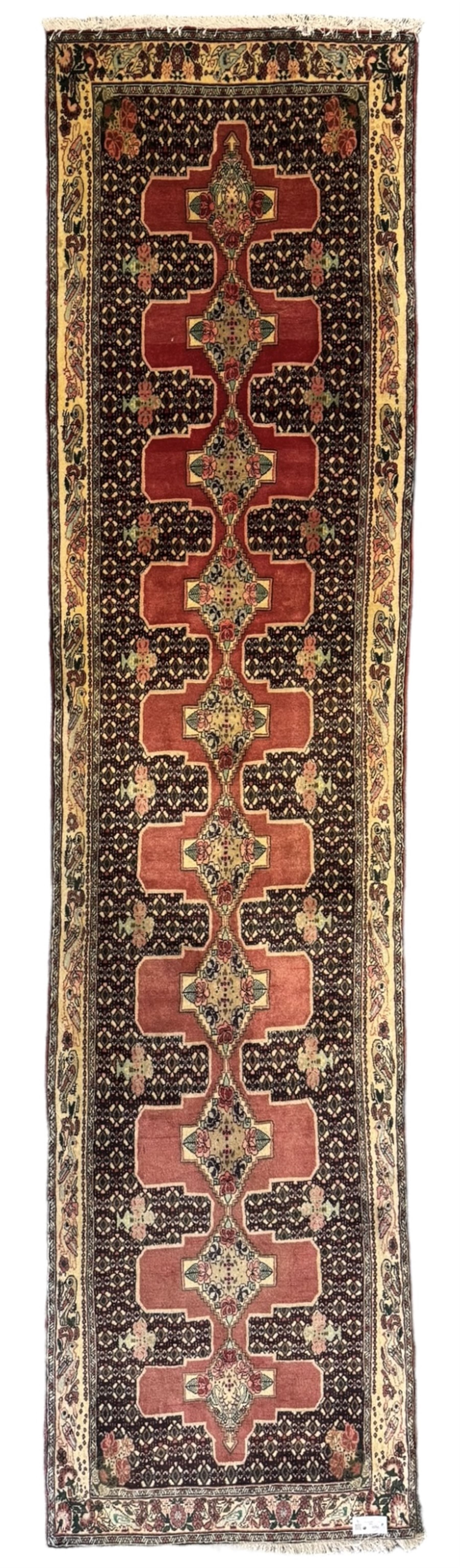 Kurdish rose ground runner rug, set with a series of ten floral medallions on linked field, the border decorated with stylised flower heads and bird motifs 