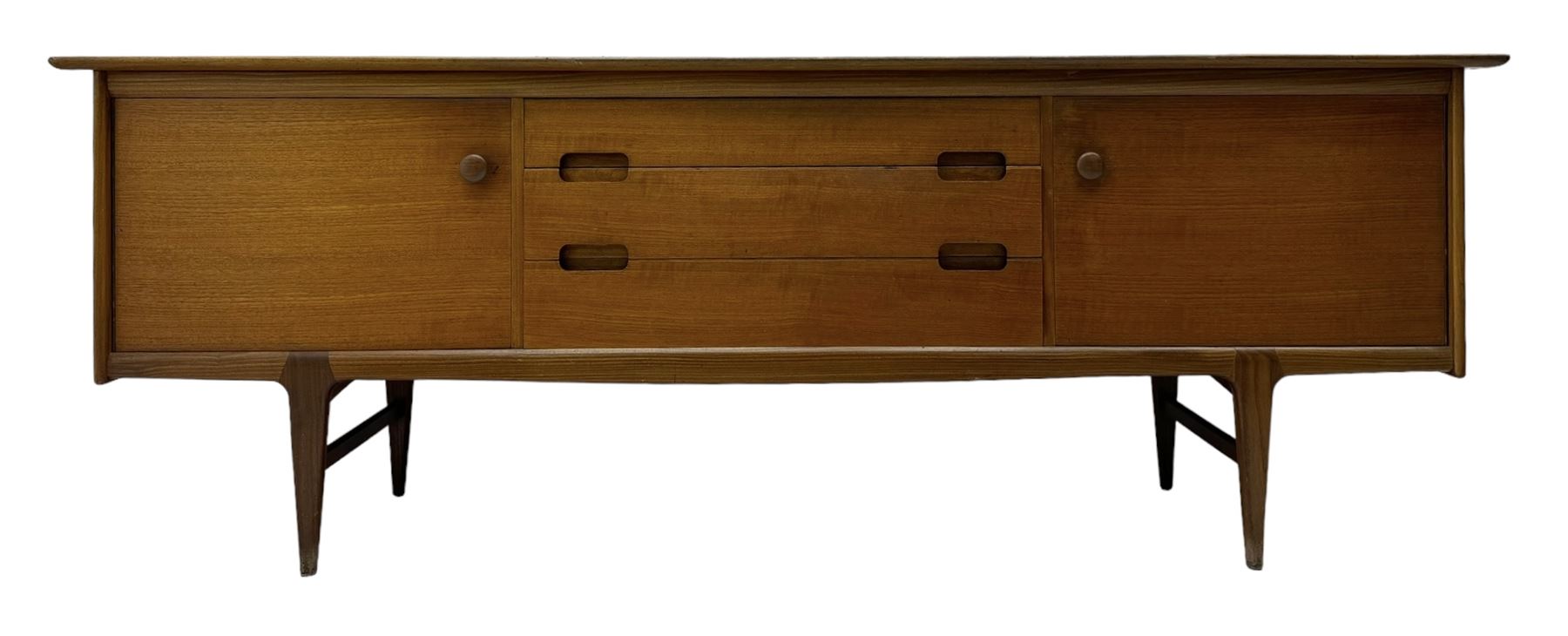 Younger - mid-20th century teak sideboard, rectangular top over three central drawers with recessed handles, flanked by two cupboard doors enclosing two shelves, on tapered supports joined by stretchers