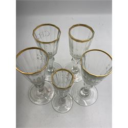 Set of four 19th century Baccarat liqueur/sherry glasses, circa 1820, with panelled bucket bowls and gilt rims, engraved CEG, to faceted knopped stems, together with another smaller example, H14cm and H12cm (5)