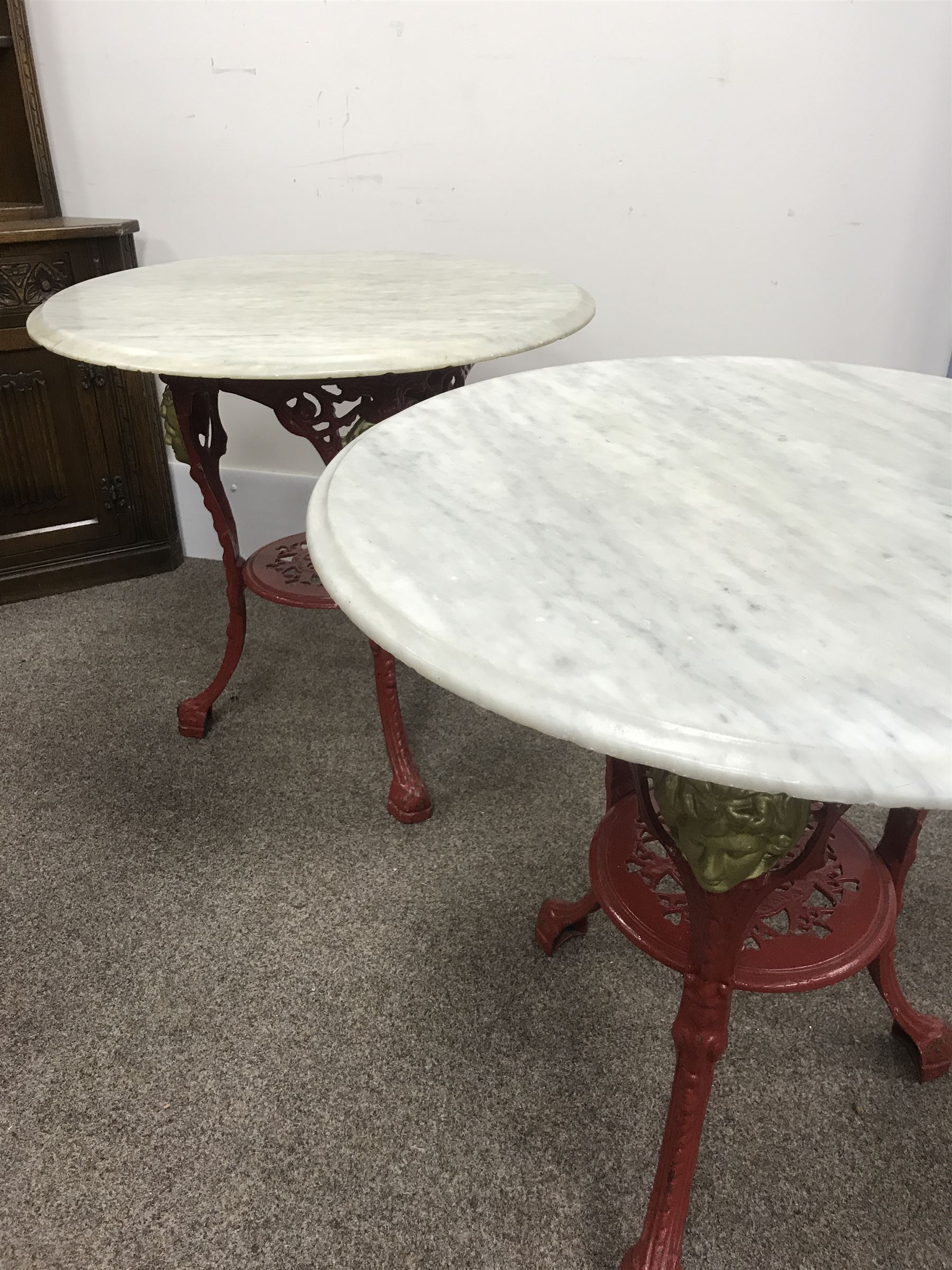 Pair cast iron Britannia pub tables, two red, small marble tops 