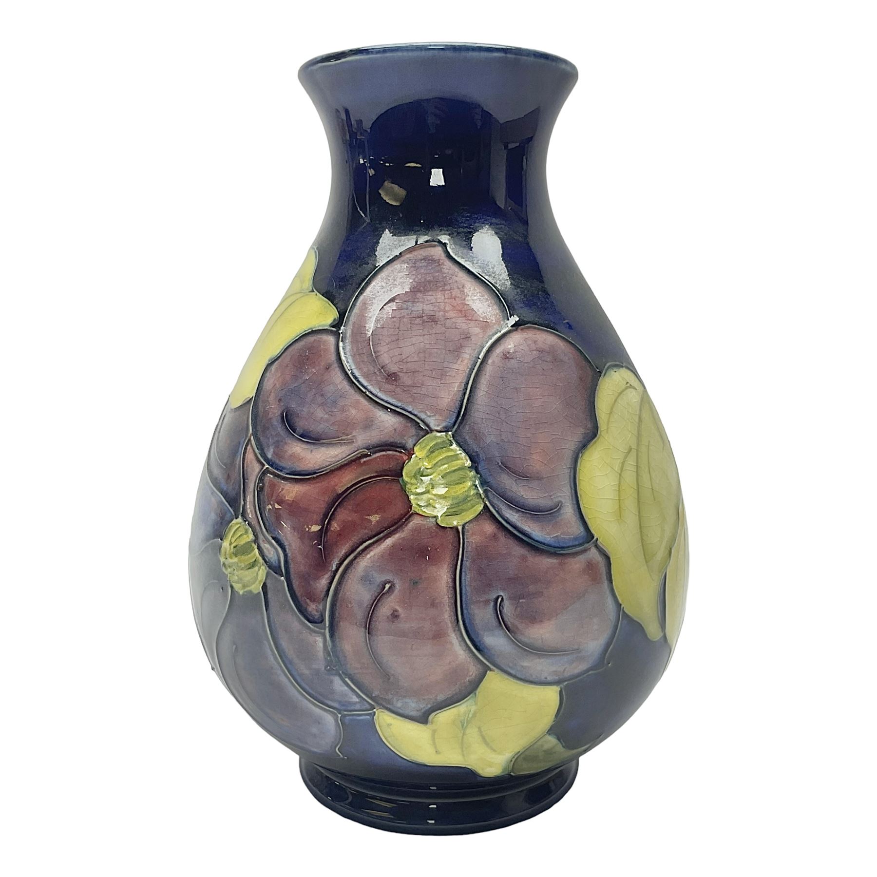 Moorcroft Clematis pattern vase of baluster form, upon a blue ground, with painted and impressed marks beneath, H22cm