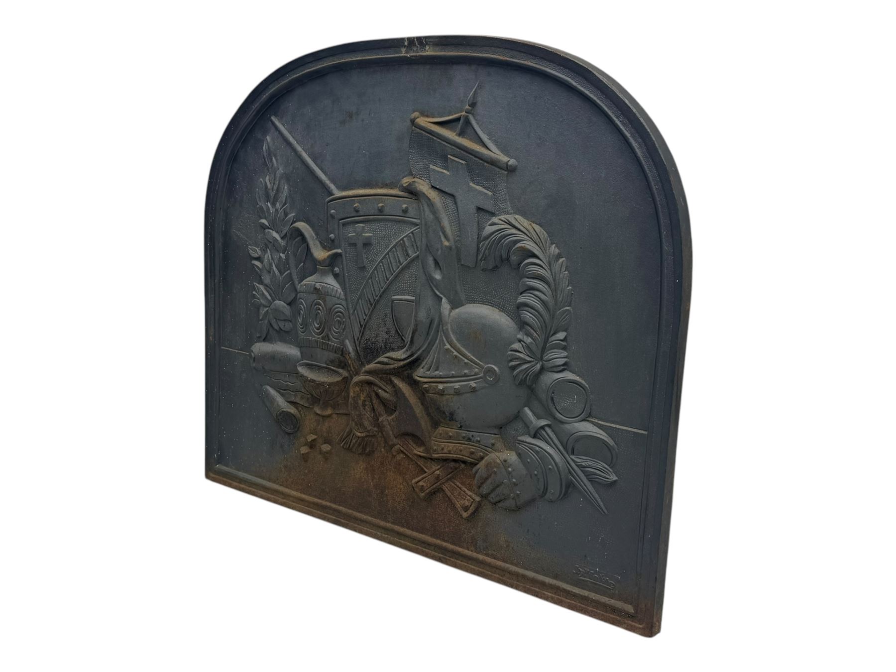 French cast iron fireback, arched form with relief of medieval armour and heraldic symbols, including a shield with a cross and a plumed helmet