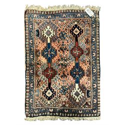 Persian prayer purple ground, decorated with three pointed buildings over tailing lozenge patterned field (111cm x 82cm); and a small Persian rug or mat, overall geometric design (81cm x 56cm)