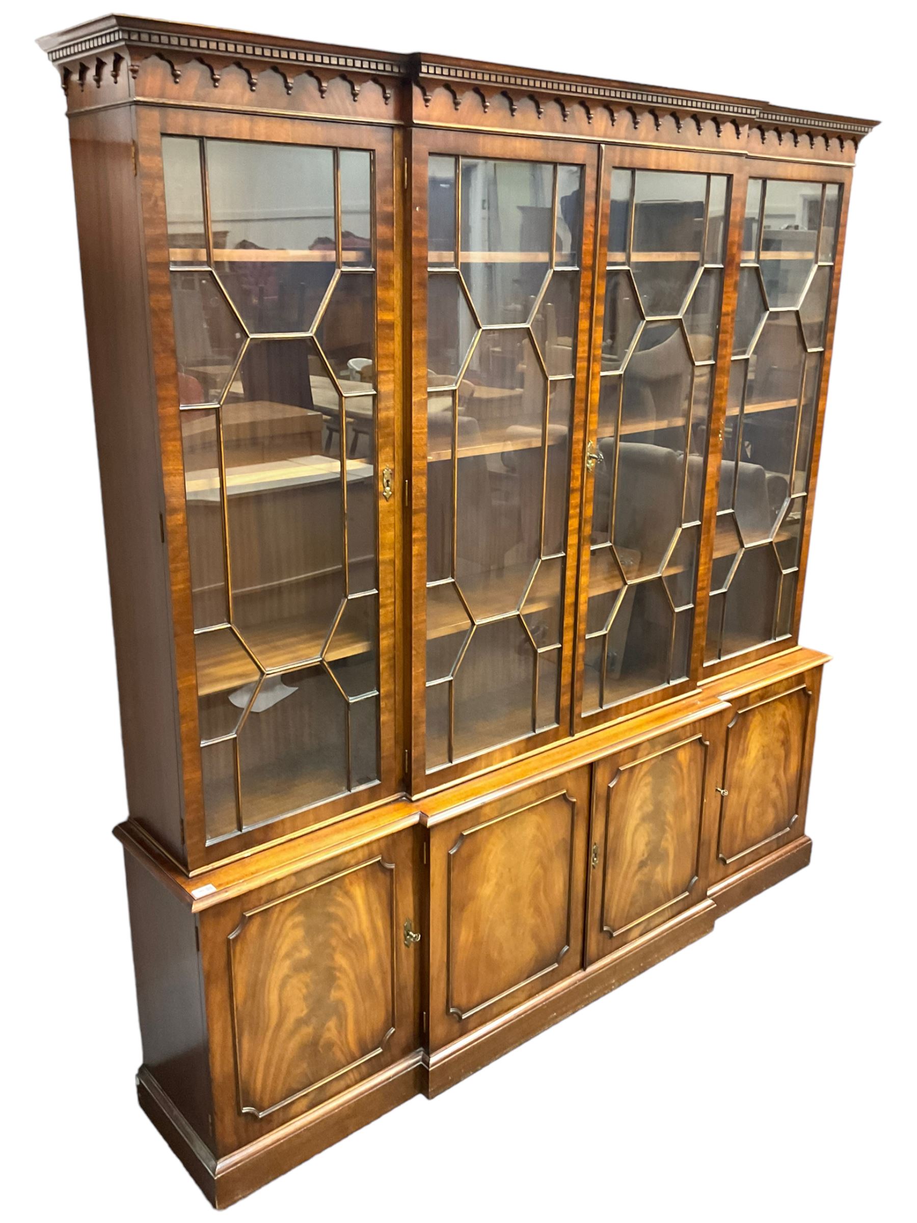 Bevan Funnell - Georgian design mahogany breakfront bookcase, moulded dentil and arcaded frieze over four astragal glazed doors, four cupboards below enclosed by figured doors, on skirted base