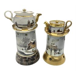 Two 19th century continental teapots and warmers, each teapot upon a cylindrical warming base in the form of a castle, hand printed with winter landscapes, largest H22cm 