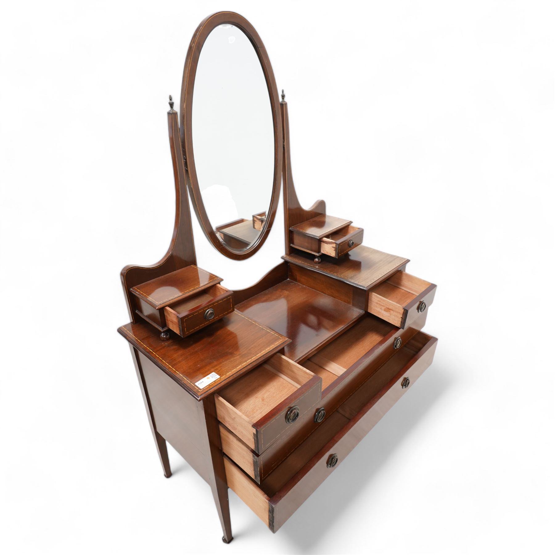 Edwardian inlaid mahogany drop-centre dressing table, bevelled oval swing mirror over trinket drawers, fitted with two short and two long drawers, on square tapering supports with brass castors