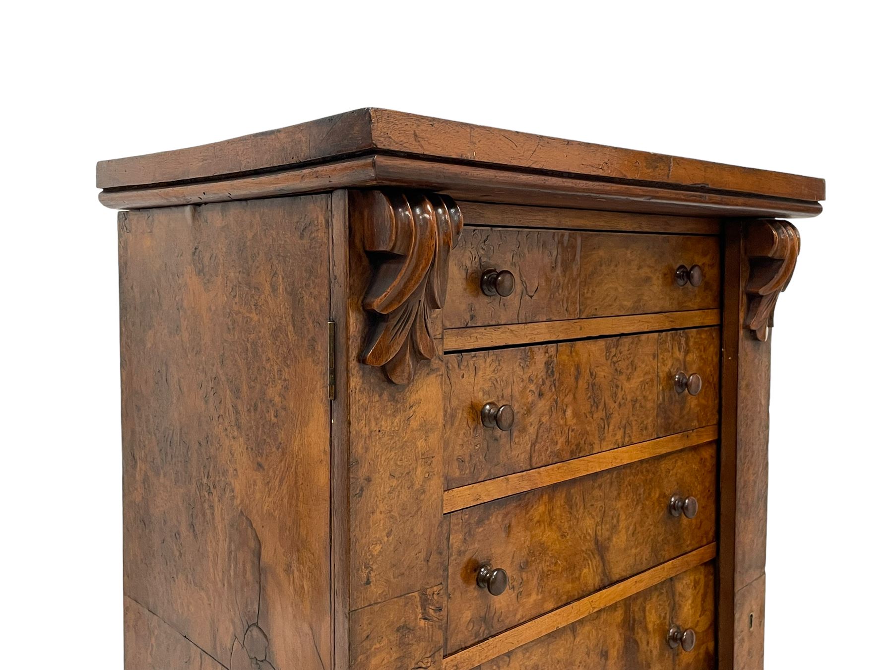 Victorian burr walnut Wellington chest, rectangular top with book-matched veneers, two hinged uprights with scrolled foliage carved brackets enclosing seven graduating drawers, on plinth base 