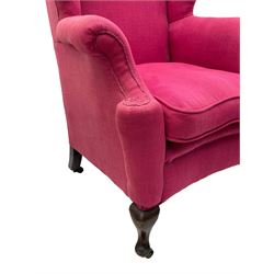 Georgian design hardwood-framed wingback armchair, arched cresting rail over curved wingback, rolled arms on scrolled cushioned supports, reverse bow-front, upholstered in claret red fabric with loose seat cushion, on cabriole front feet and brass castors 