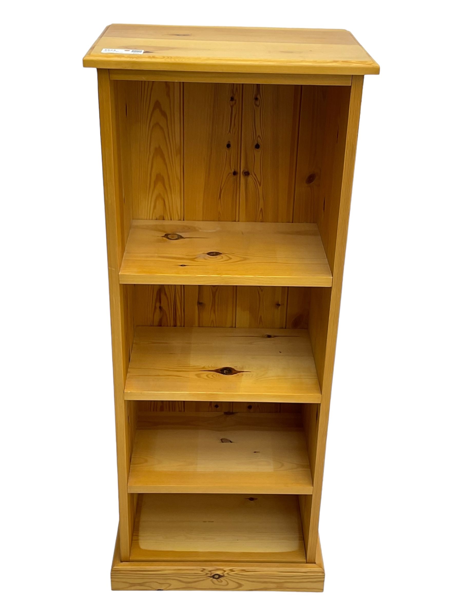 Narrow pine open bookcase, rectangular top over three shelves, on plinth base