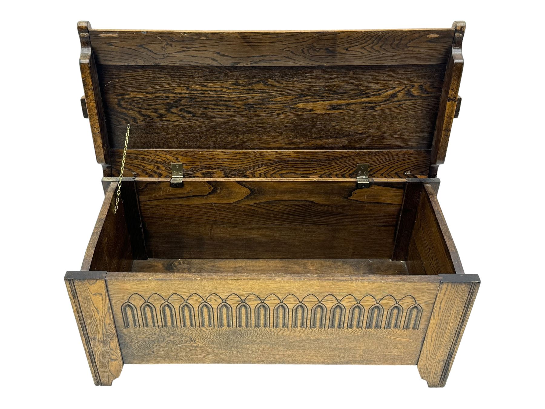 20th century oak coffer or blanket chest, rectangular hinged top over repeating Gothic arch carved front and shaped sides, constructed with pegged joints, on stile supports