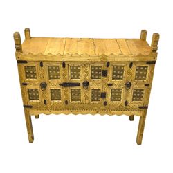 Late 19th century Indian teak damchiya chest, panelled front enclosed by single door, with metal bands and handles 