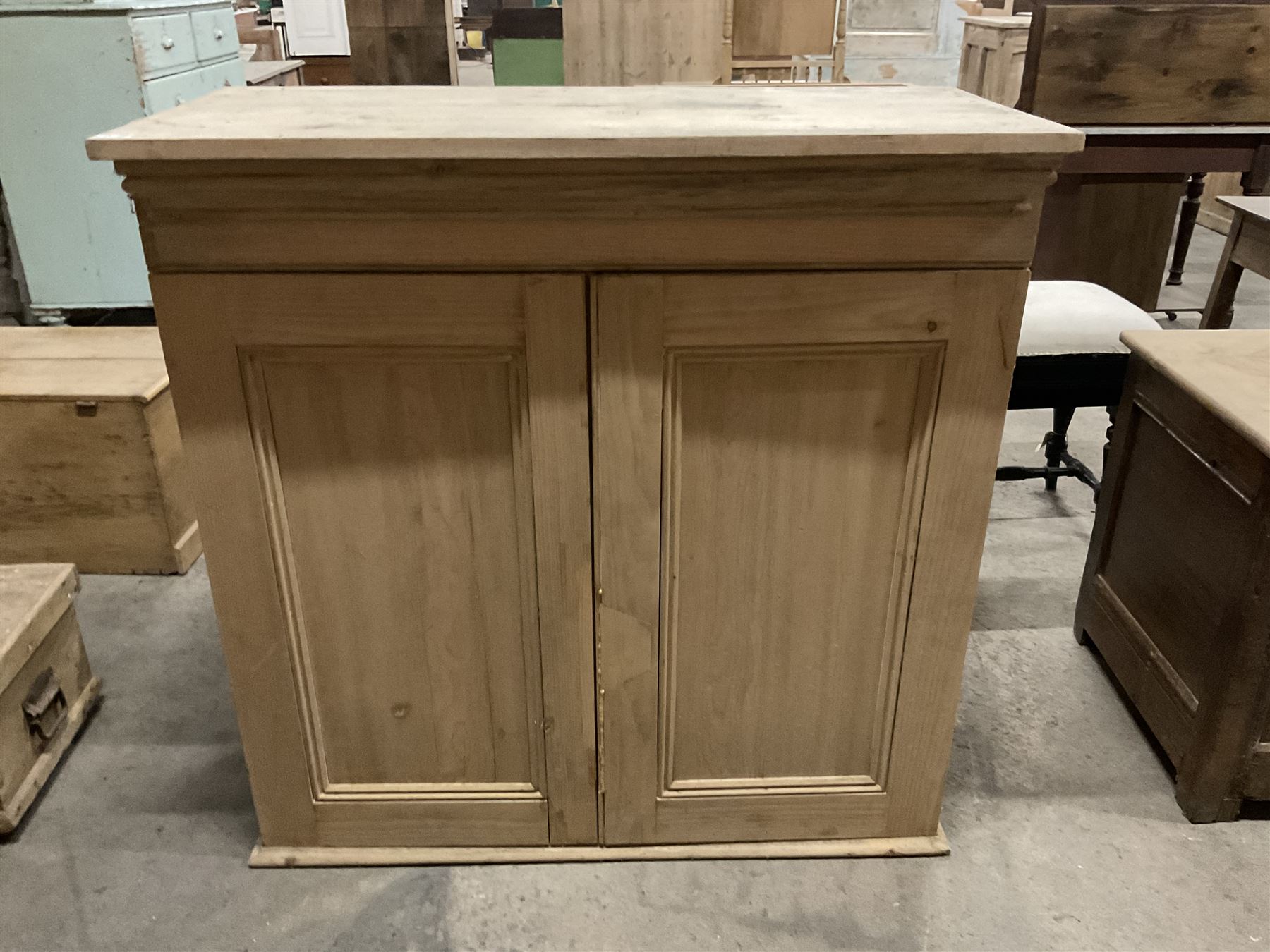 Stripped pine cupboard or bookcase, projecting cornice over two panelled doors, enclosing two shelves - THIS LOT IS TO BE COLLECTED BY APPOINTMENT FROM THE OLD BUFFER DEPOT, MELBOURNE PLACE, SOWERBY, THIRSK, YO7 1QY