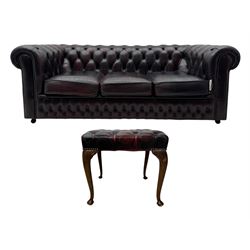 Chesterfield three-seat sofa, traditional shaped upholstered in deeply buttoned dark red leather; together with similar footstool 