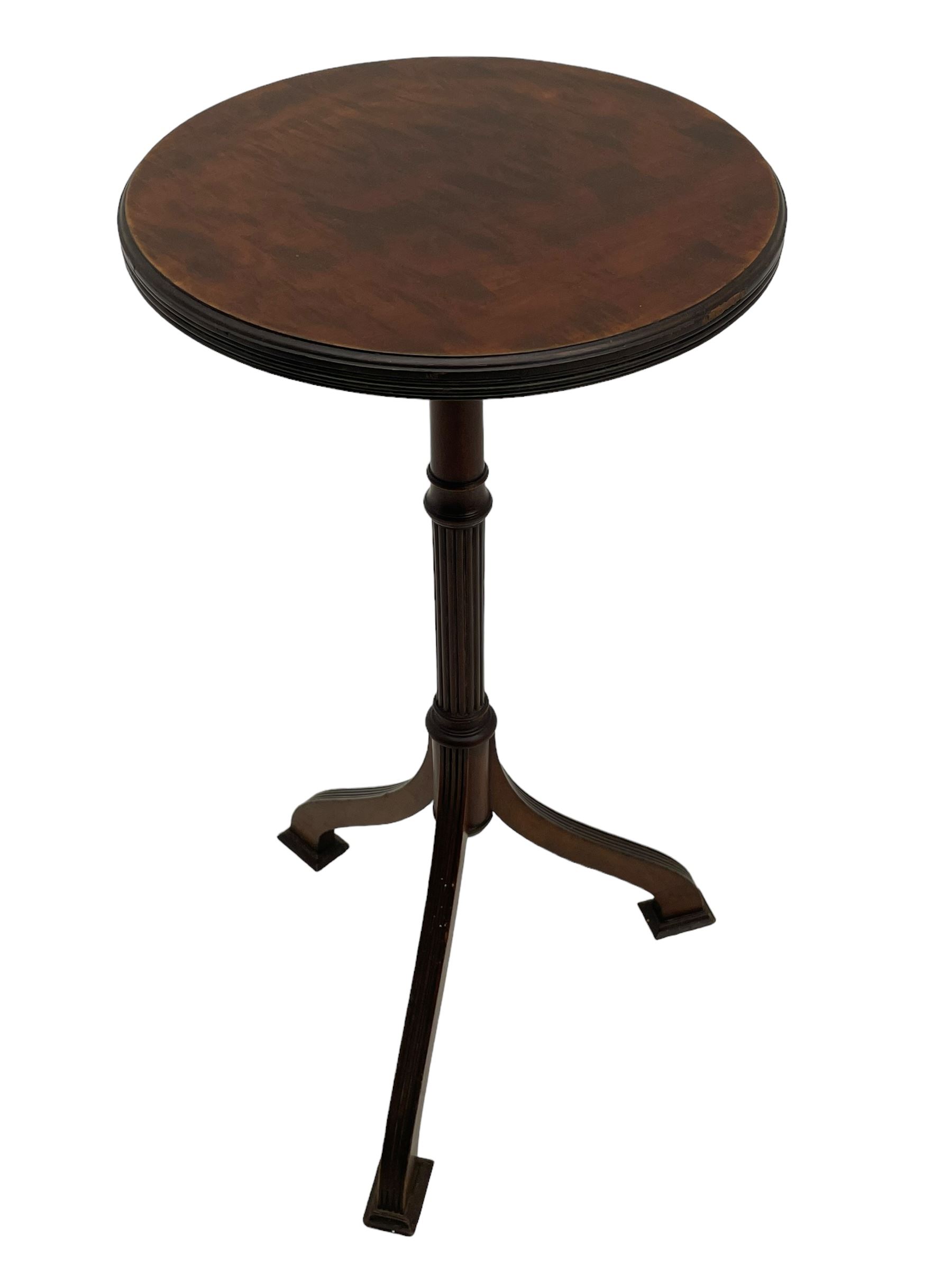 Early 20th century mahogany wine table, figured circular top with reeded edge, on turned and reed moulded stem, three reeded tapered supports on rectangular moulded pad feet 