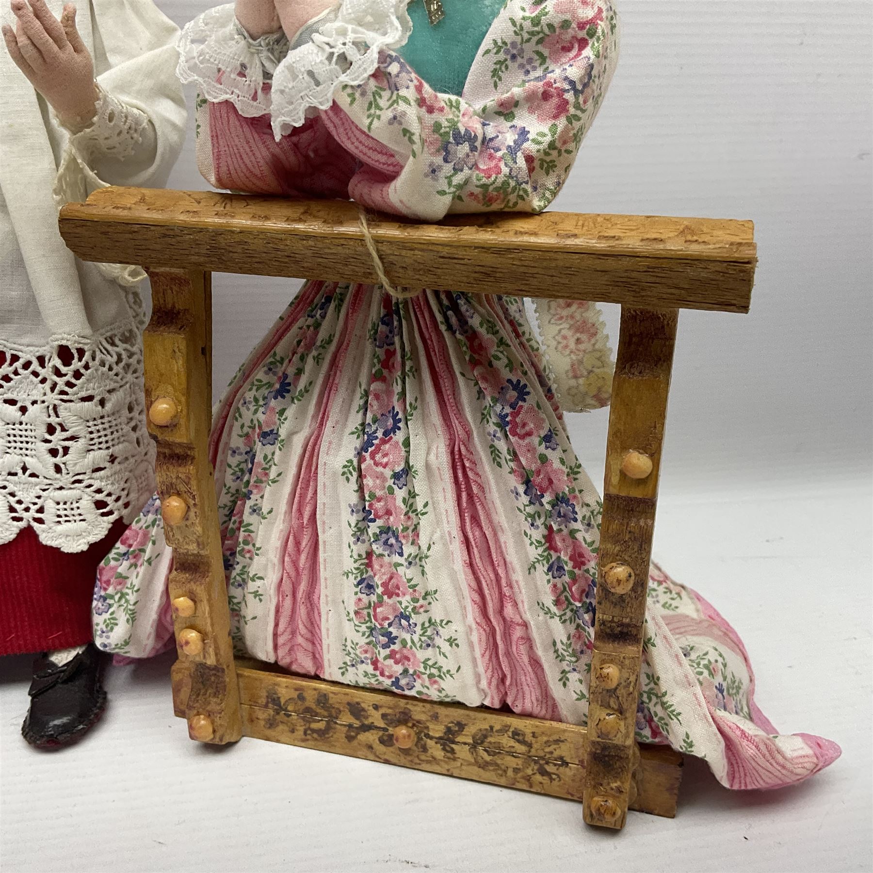 Anna Meszaros Hungary - two hand made needlework figurines, each of a young girl kneeling by an alter rail praying H28cm; together with another similar of a chorister H29cm (3)  Auctioneer's Note: Anna Meszaros came to England from her native Hungary in 1959 to marry an English businessman she met while demonstrating her art at the 1958 Brussels Exhibition. Shortly before she left for England she was awarded the title of Folk Artist Master by the Hungarian Government. Anna was a gifted painter of mainly portraits and sculptress before starting to make her figurines which are completely hand made and unique, each with a character and expression of its own. The hands, feet and face are sculptured by layering the material and pulling the features into place with needle and thread. She died in Hull in 1998.