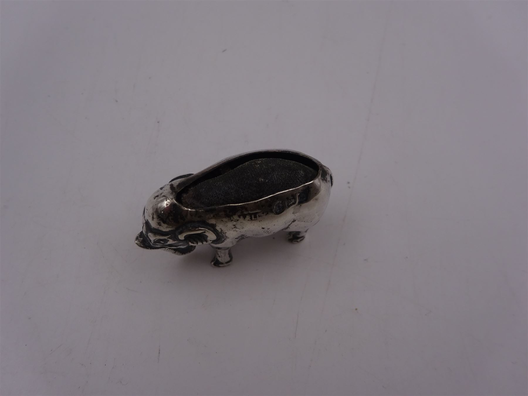 Edwardian silver mounted novelty pin cushion, in the form of an elephant, with cushioned back, hallmarked Birmingham 1906, maker's mark worn and indistinct, L4cm, H3.5cm